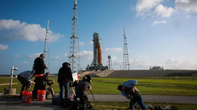 People photograph Nasa's next-generation moon rocket, the Space Launch System (SLS) rocket with the Orion crew capsule, on Pad 39B ahead of the Artemis II mission launch