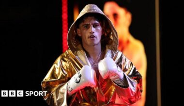 Royston Barney-Smith makes his way to the ring, dressed in a gold gown and wearing white boxing gloves