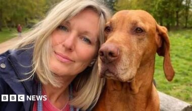 Harvey Cooper wearing a dark t-shirt standing in front of grass and trees