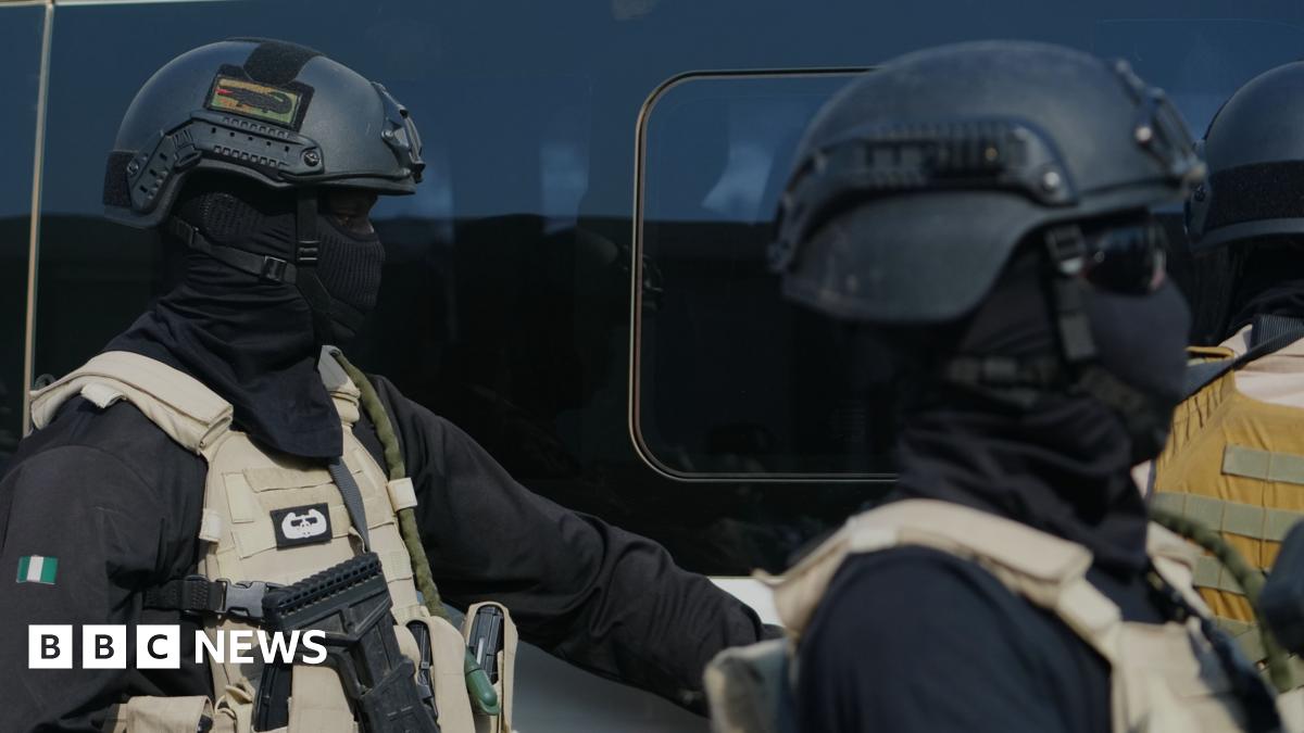 Two government forces personnel wearing all black and beige vests.