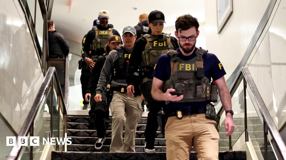 Shattered glass from a barrier is seen closeup at the Washington Hilton hotel. Some is on brown carpeting in front of it and a staircase is behind the glass