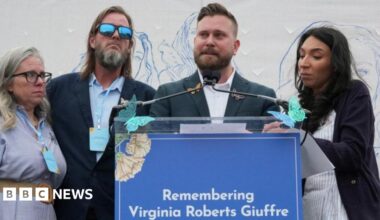 Virginia Giuffre's brothers, Sky Roberts (second right) and Danny Wilson, and her sisters-in-law, Lanette Wilson (on left) and Amanda Roberts, stand together during a "butterfly" vigil commemorating the one-year anniversary of the death of Virginia Roberts Giuffre.