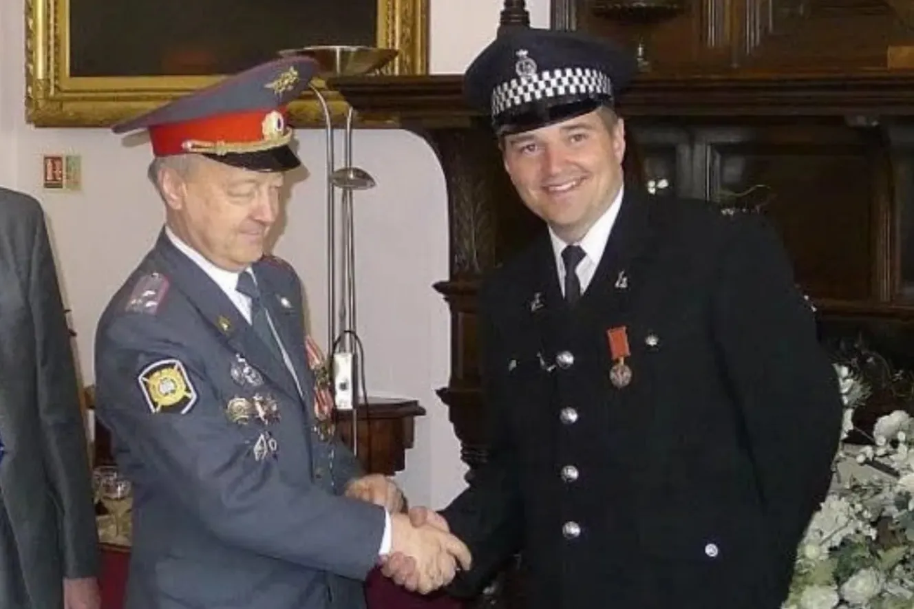 Mark Bullen, a former British police officer, shakes hands with a man in a Russian uniform.
