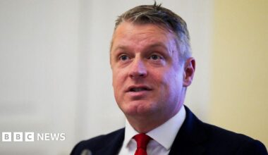 Defence Minister Luke Pollard, with short grey hair, wearing a white shirt, red tie and black suit.