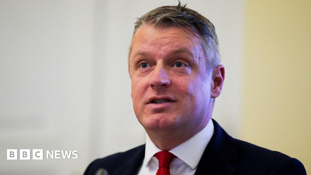 Defence Minister Luke Pollard, with short grey hair, wearing a white shirt, red tie and black suit.