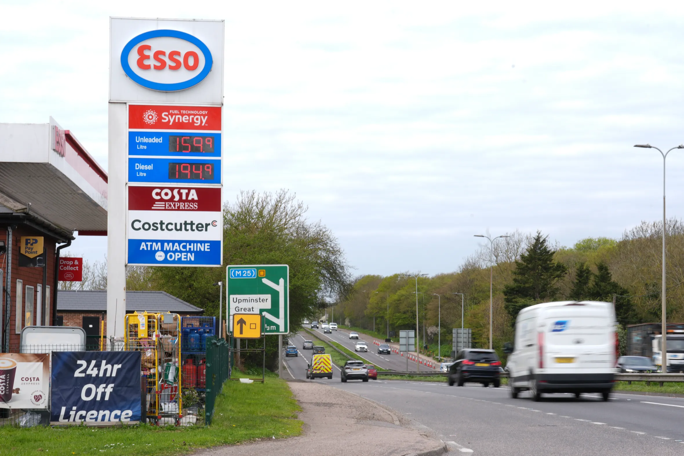 An Esso garage sign displaying unleaded petrol at 159.9 pence per litre and diesel at 194.9 pence per litre, alongside a busy A127 road.