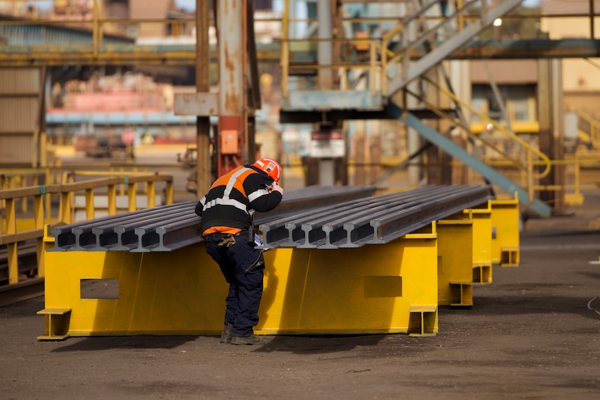 A workers inspects a recently manufactured rail track