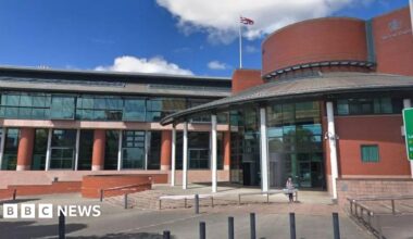 Streetview image of Preston Crown Court, which is a large redbrick and glass building with a round entrance on the right hand side.
