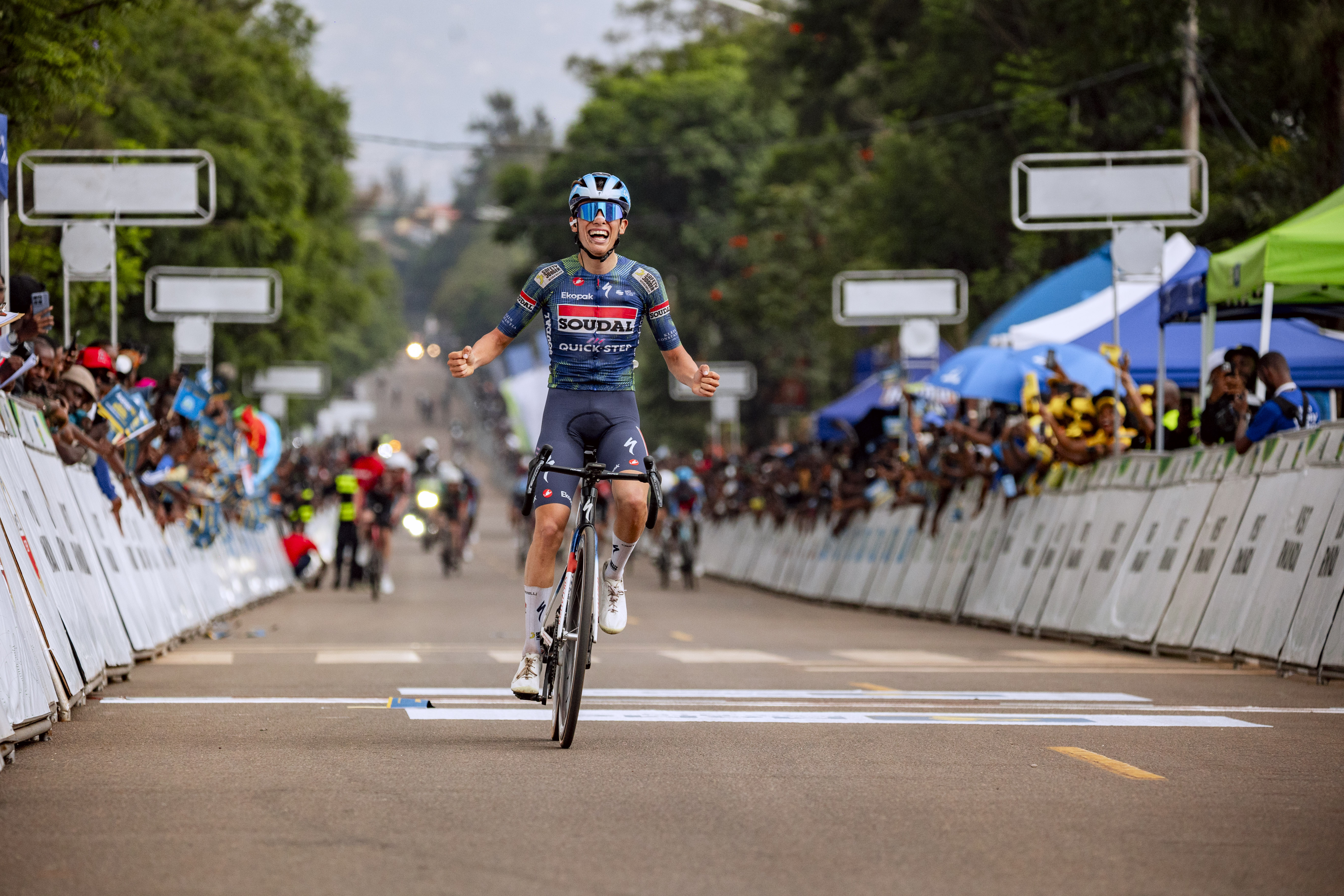 Enrique Bravo cross the finish line with the win and shows emotion on stage 7 at 2026 Tour de Rwanda as the chase group sprint in behind him.