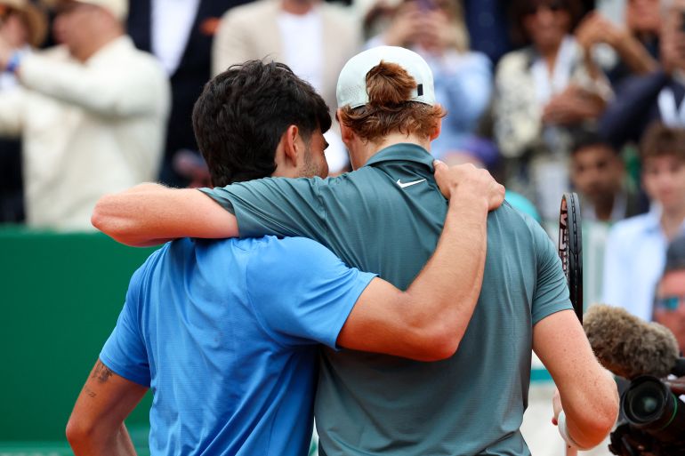 Italy's Jannik Sinner (R) embraces with Spain's Carlos Alcaraz after winning the Monte Carlo ATP Masters Series Tournament final tennis match on Court Rainier III at the Monte-Carlo Country Club in Roquebrune-Cap-Martin, south-eastern France on April 12, 2026. (Photo by Valery HACHE / AFP)
