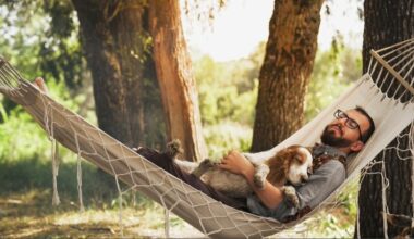A man and a dog sleeping in hammock in forest