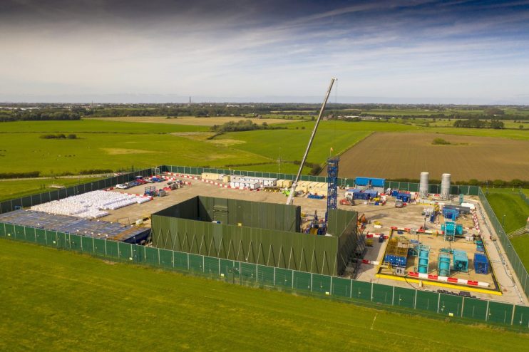 Cuadrilla fracking site with drilling equipment and safety barriers, highlighting energy extraction operations in a rural ...