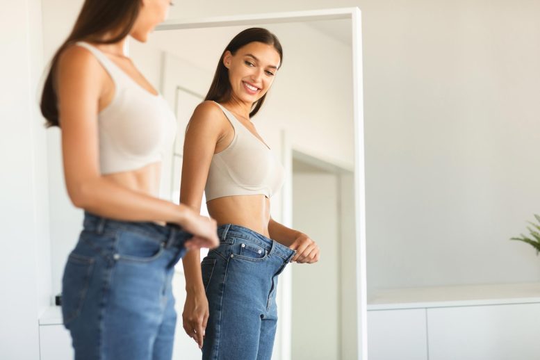 Excited Young Fit Woman Weight Loss Jeans