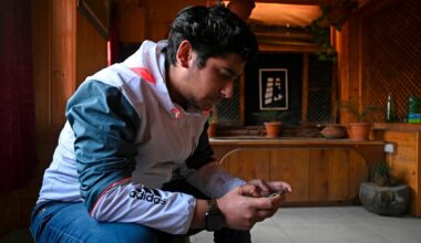 seated man looking at ell phone