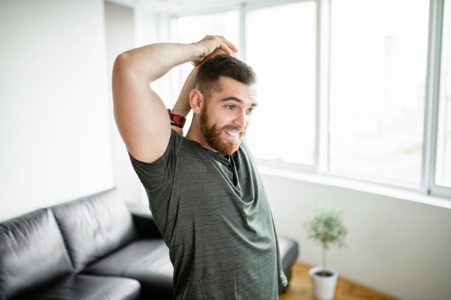 Young man stretching before intensive training at home