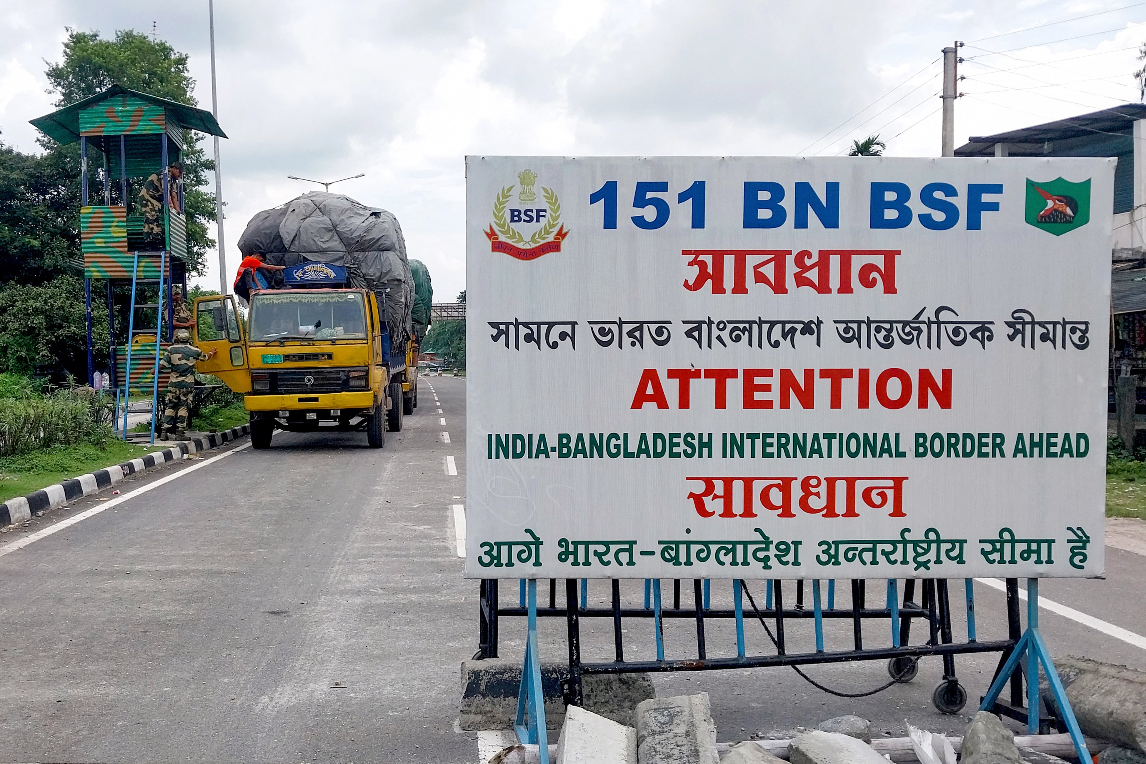 Border Security Force (BSF) personnel inspect a truck carrying supplies to Bangladesh at the India-Bangladesh border in Fulbari on the outskirts of Siliguri on August 7, 2024