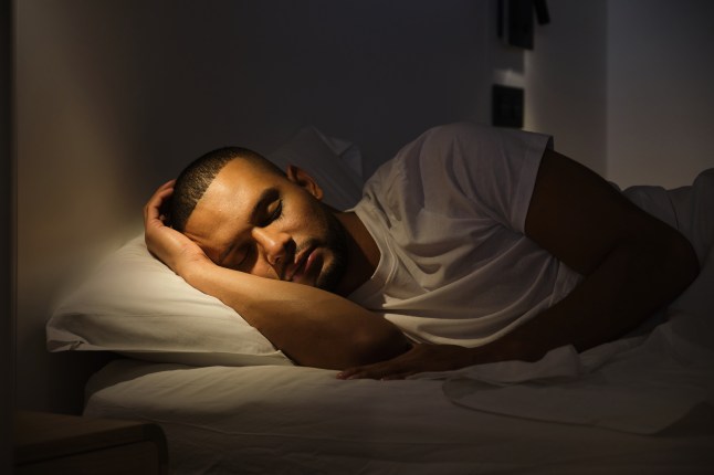 Serene man sleeping soundly in bed at night
