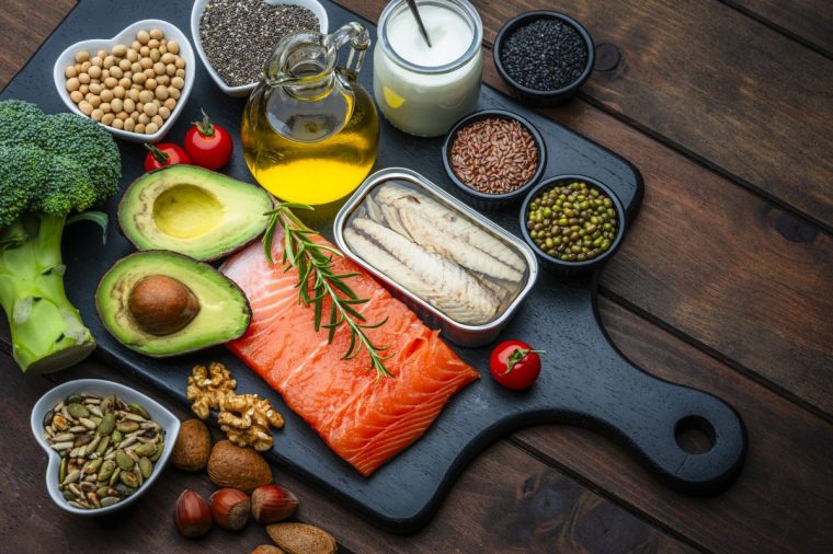 Group of healthy ingredients high in unsaturated fatty acid and Omega-3. Food that improve cholesterol levels, lower blood pressure and reduce inflammation. Olive oil, avocado, salmon, sardine, chia seed, nuts - stock photo