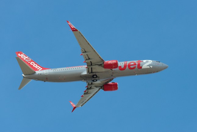 A Jet2 plane flies in the blue sky.