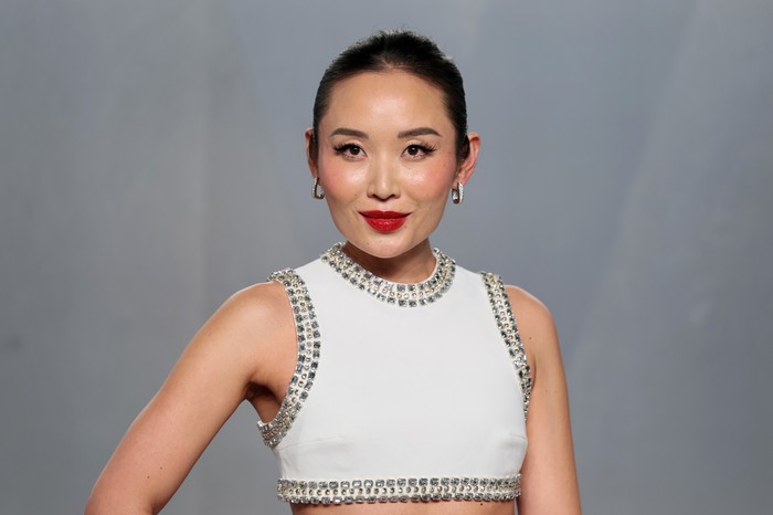 Li Jun Li in a bejewelled white crop top, posing on a red carpet