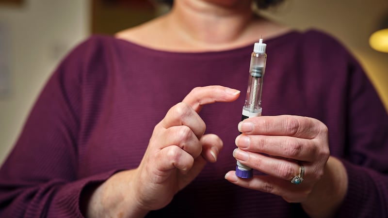 Woman holding a GLP-1 shot of Ozempic