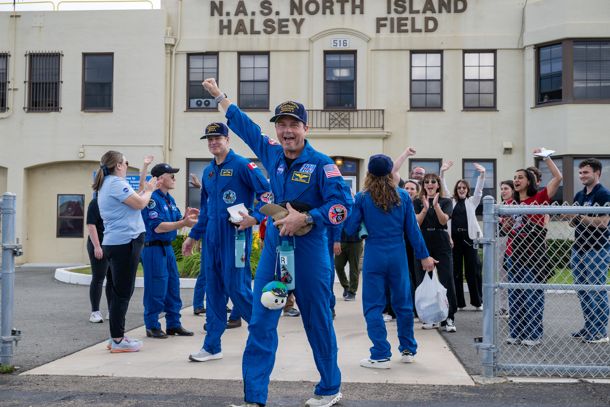 Artemis 2 NASA astronaut Reid Wiseman cheers while carrying Rise, the mission mascot.