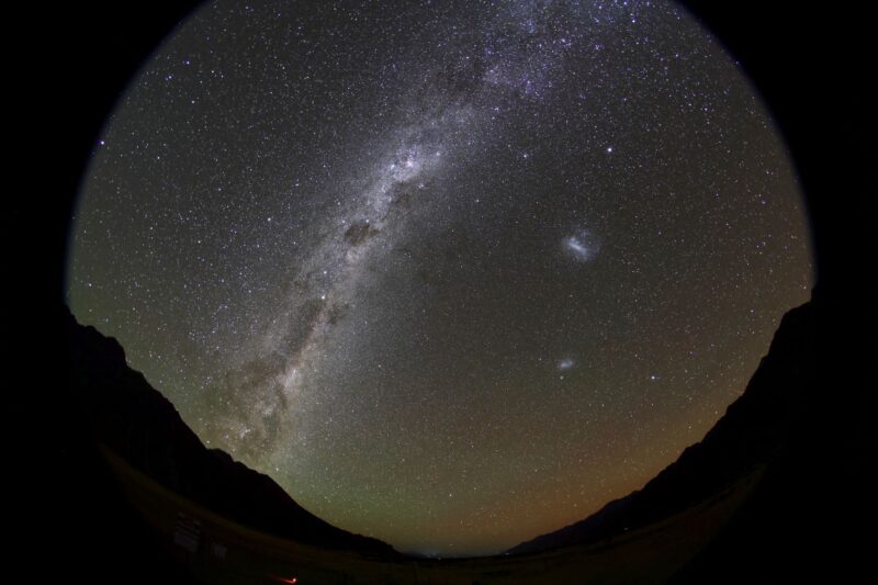 A glowing, cloudy band with dark streaks and patches, and 2 small irregular bright clouds.