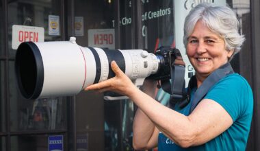Smiling woman holding Canon RF 400mm f/2.8 lens