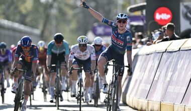 Tim Merlier celebrates his win with one arm raised