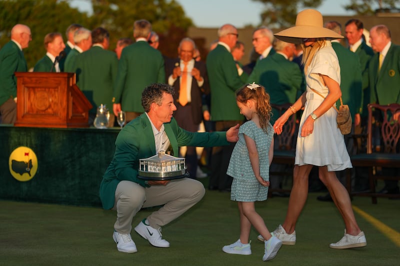Rory McIlroy of Northern Ireland kneels near his daughter, Poppy McIlroy, during the Green Jacket ceremony. Photograph: Ben Jared/PGA Tour via Getty