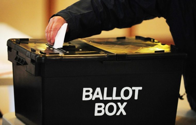 File photo dated 06/05/10 of a voter placing a ballot paper in the ballot box at the polling station at Market Hall in Swadlincote, Derbyshire. The next general election will see 16-year-olds able to vote for the first time, ministers have confirmed in wide-ranging plans to "modernise our democracy". Labour's manifesto committed the party to lowering the voting age for parliamentary elections to 16, in line with Scottish and Welsh elections.