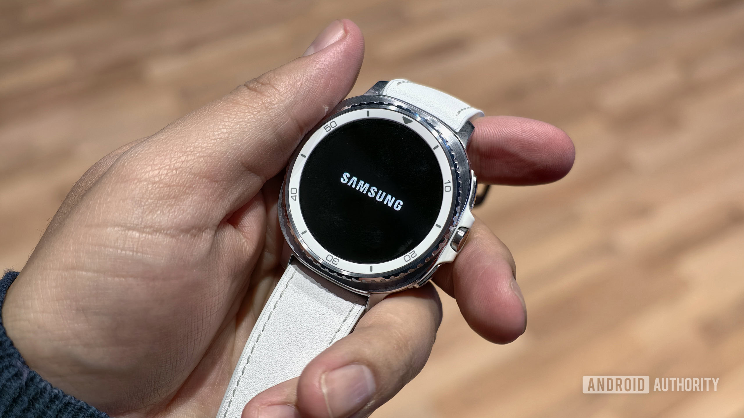 Samsung Galaxy Watch Classic in hand with Samsung logo Samsung Galaxy Watch Classic in hand with Samsung logo