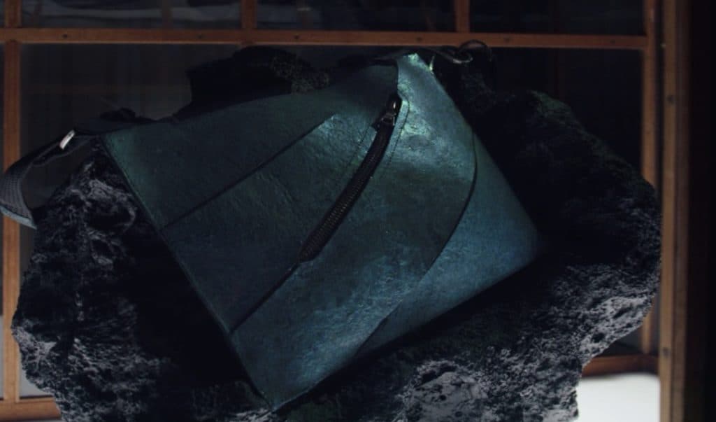 Teal leather handbag with dinosaur scratches