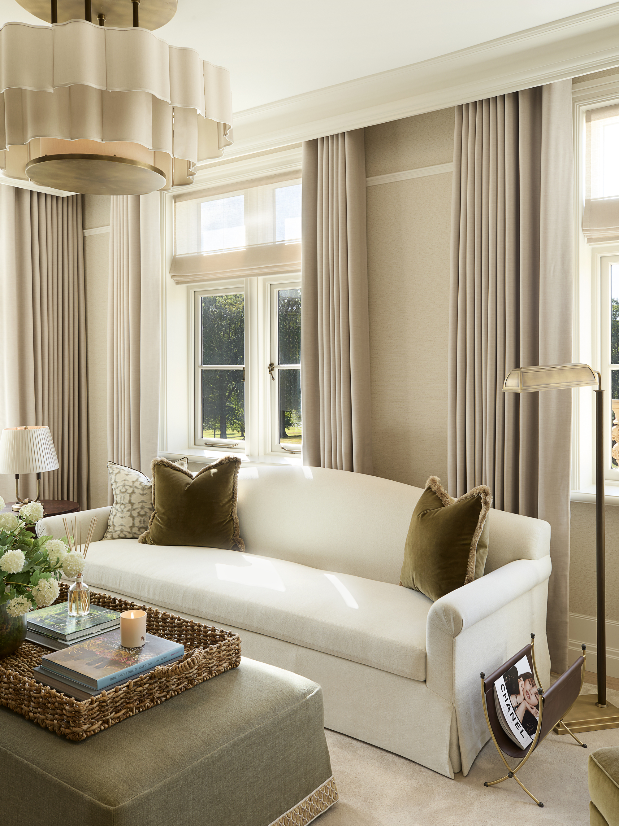 a neutral and green living room with a white sofa and green ottoman