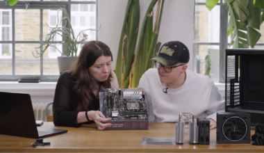 Two tech journalists looking confused at a motherboard