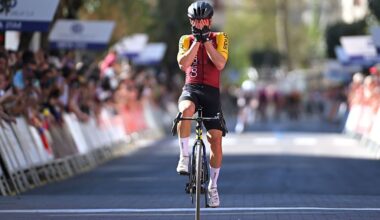 Ion Izagirre puts his hands over his face in disbelief at the finish line with Simmons in the distance