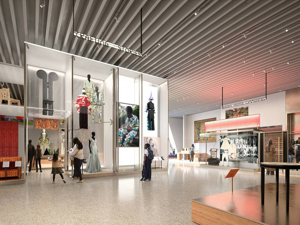 a gallery space in a museum, with people milling about looking at clothing, paintings, and more
