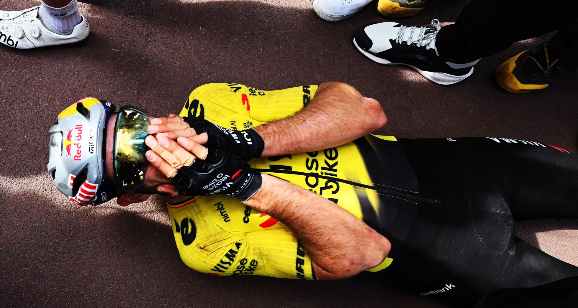 Wout van Aert lies on the ground, holding his face in disbelief after winning Paris-Roubaix 2026