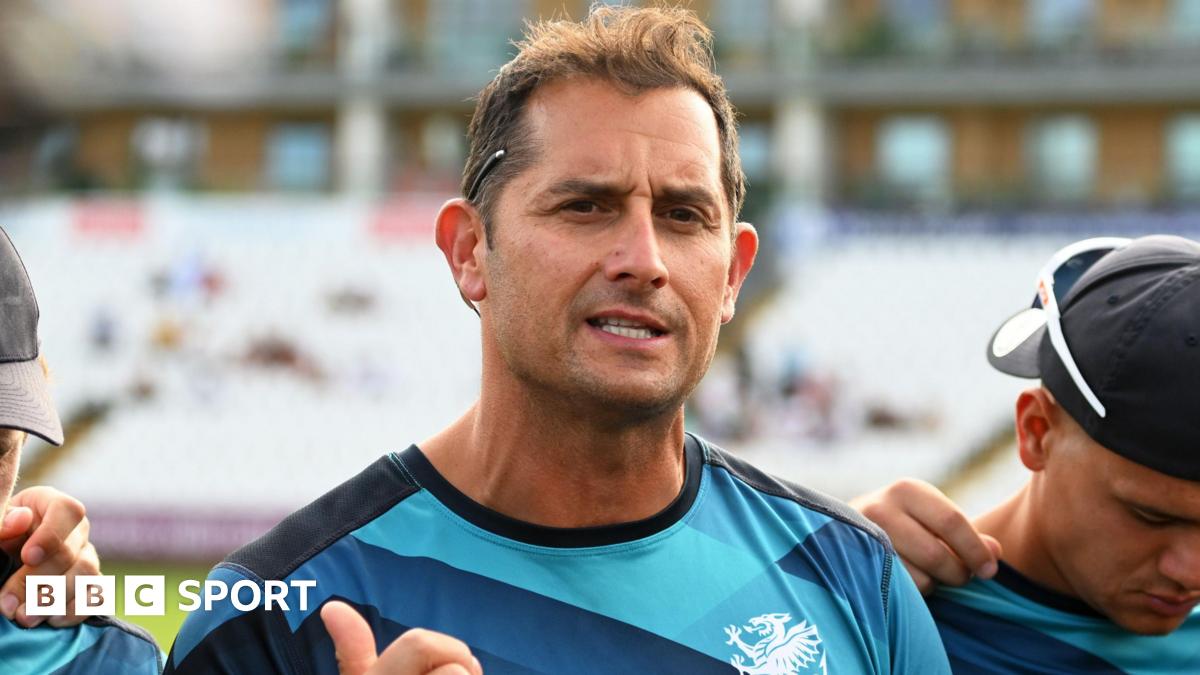 Jason Kerr, wearing a Somerset training top with navy blue, blue and light blue patterns and a white Somerset badge, while talking to his players before a T20 game against Glamorgan at the County Ground