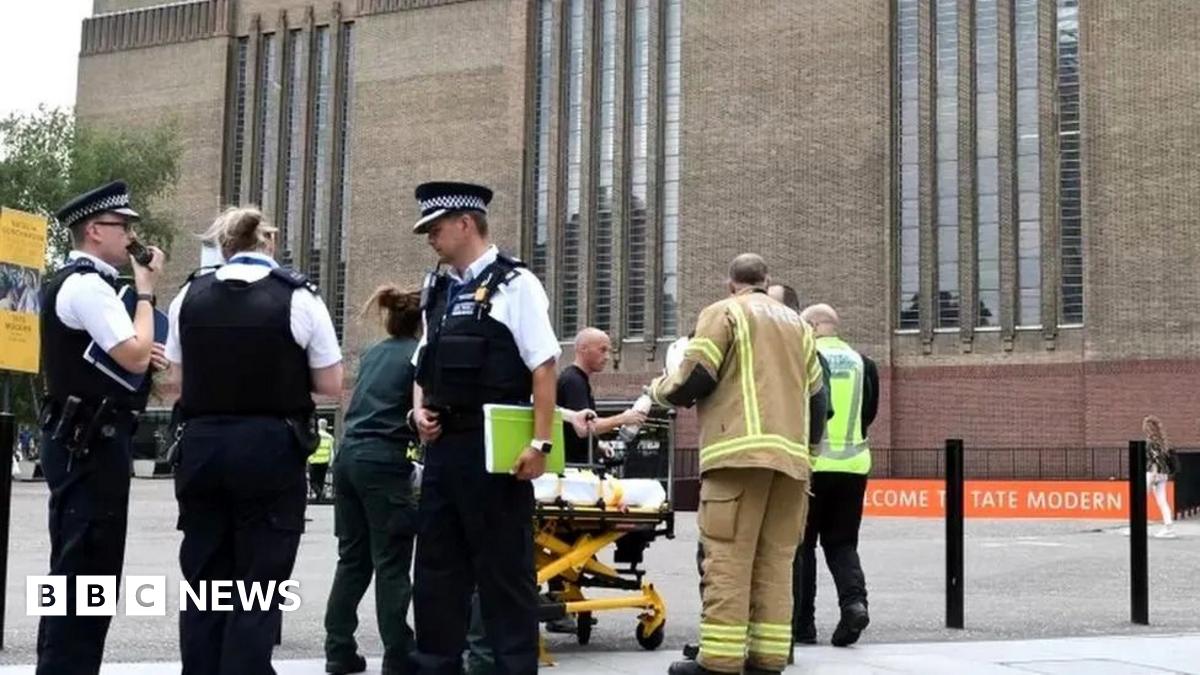 Police officers outside Tate Modern following boy's fall with stretcher behind