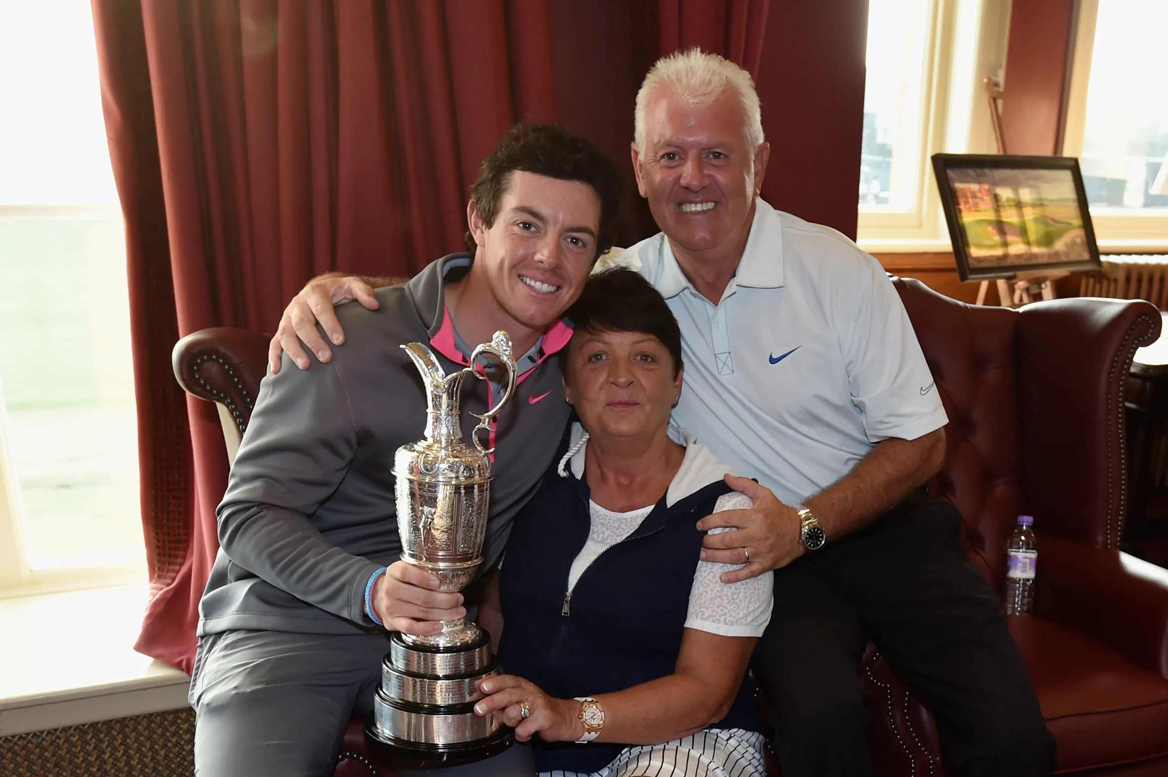 Rory McIlroy with his parents Rosie and Gerry, holding the Claret Jug trophy after his victory.