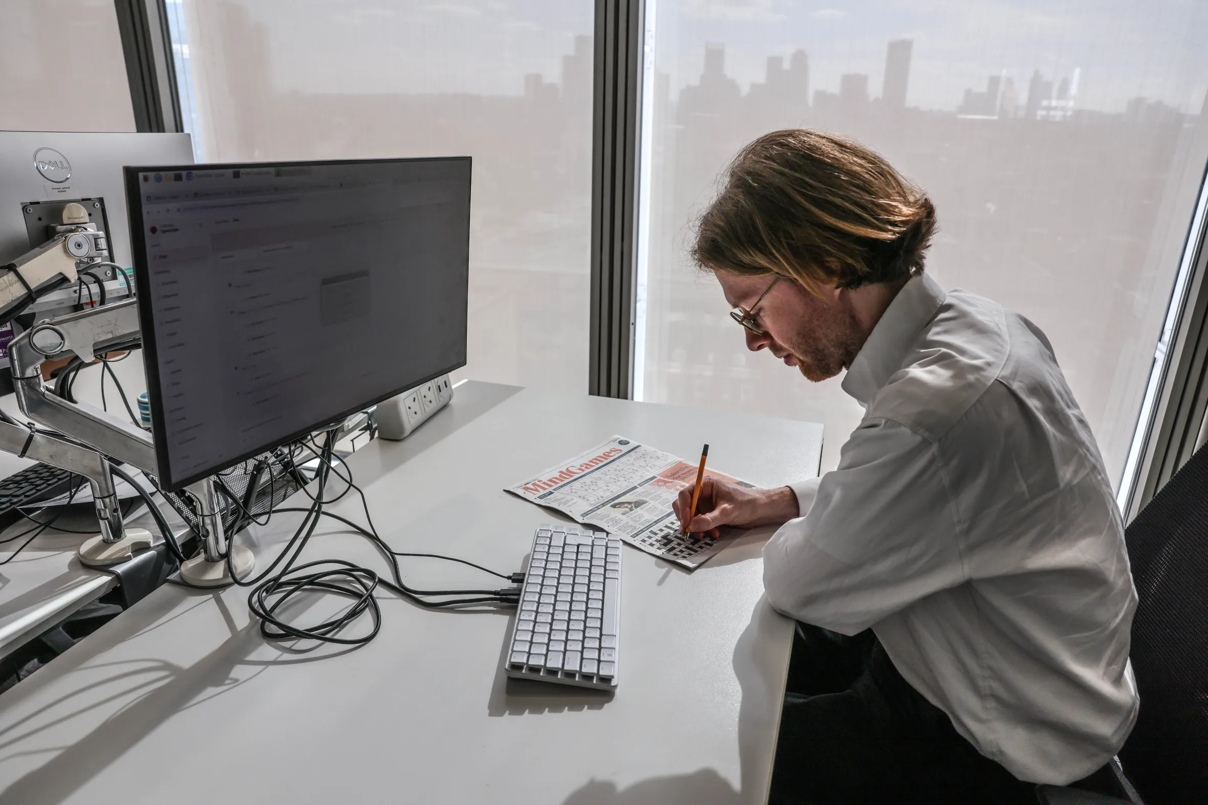 Business writer Chris Dorell with the Raspberry PI computer built into the keyboard while doing a crossword puzzle.