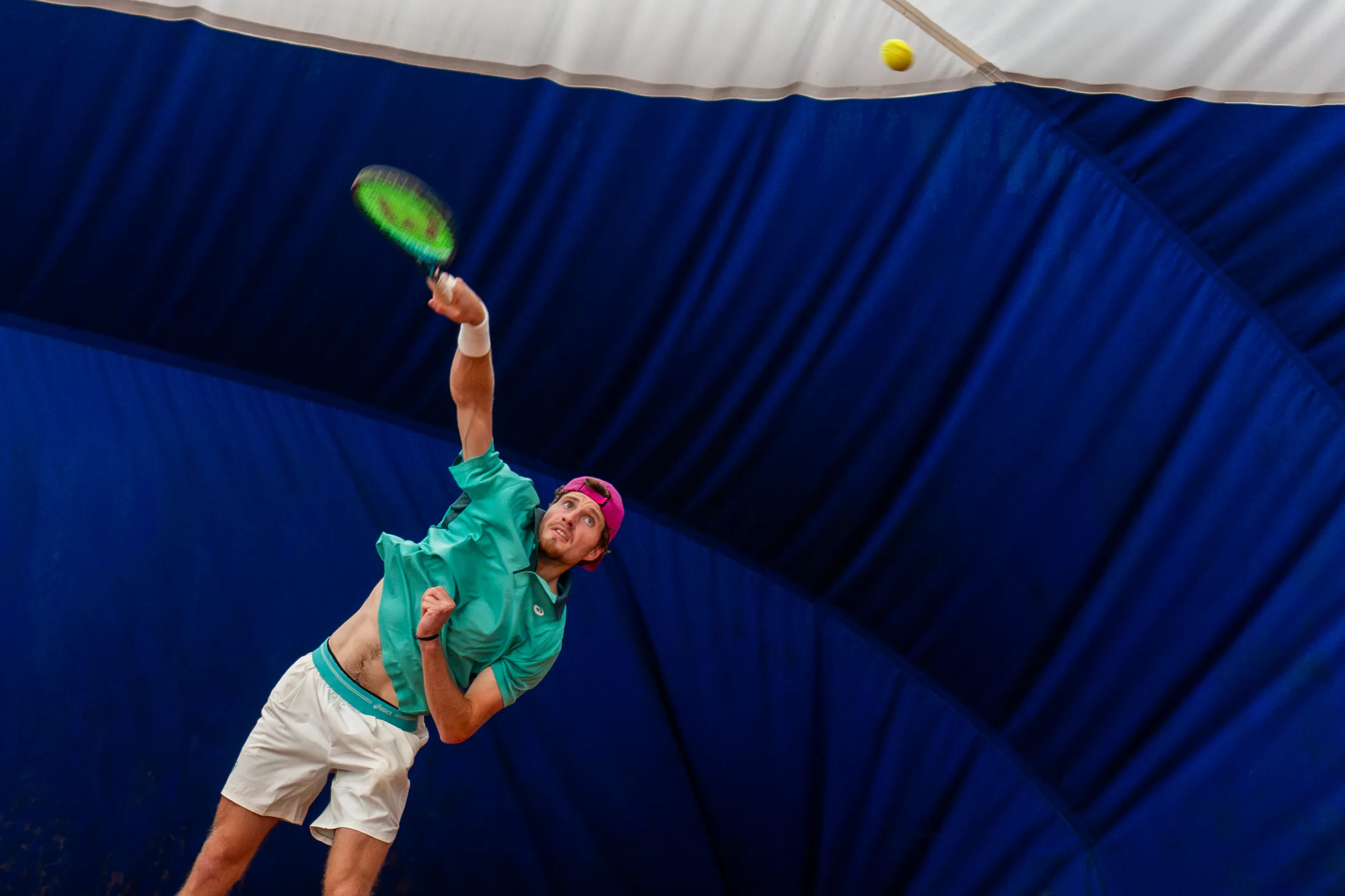 British tennis player Toby Samuel in mid-serve motion.