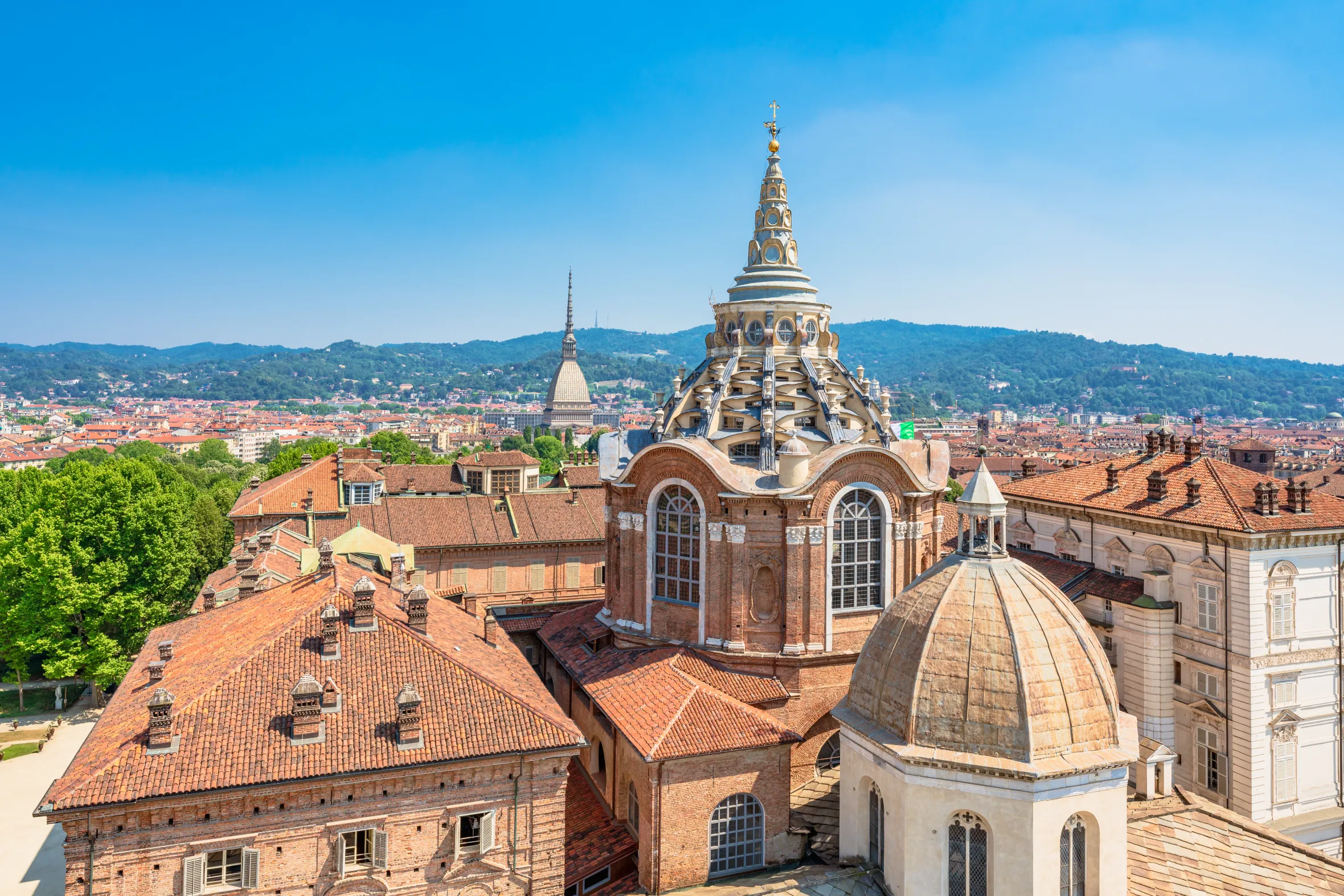 High-angle view of the Turin Cathedral and the Royal Palace with mountains in the background.