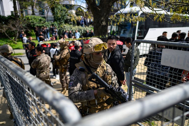 TOPSHOT - A police official stands alert near The Israeli Consulate in Istanbul on April 7, 2026, following a shootout between gunmen and police.