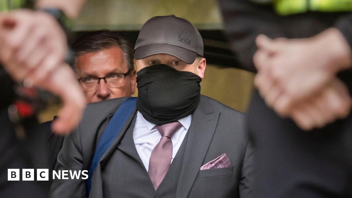 Former funeral director Robert Bush leaves Hull Crown Court, he is wearing a grey three piece suit with a purple tie and pocket square.