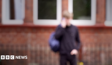 A blurred picture of a teenage boy in a school uniform. Specific details are difficult to make out.
