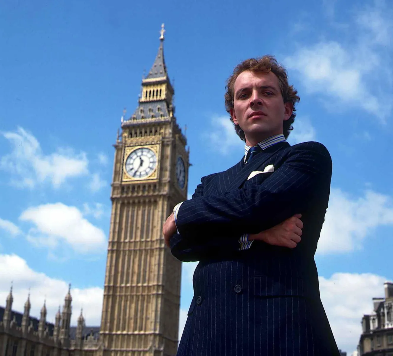 Rik Mayall as Alan B'Stard from "The New Statesman" standing in front of Big Ben.