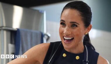 Meghan Markle wearing a sleeveless black dress and apron