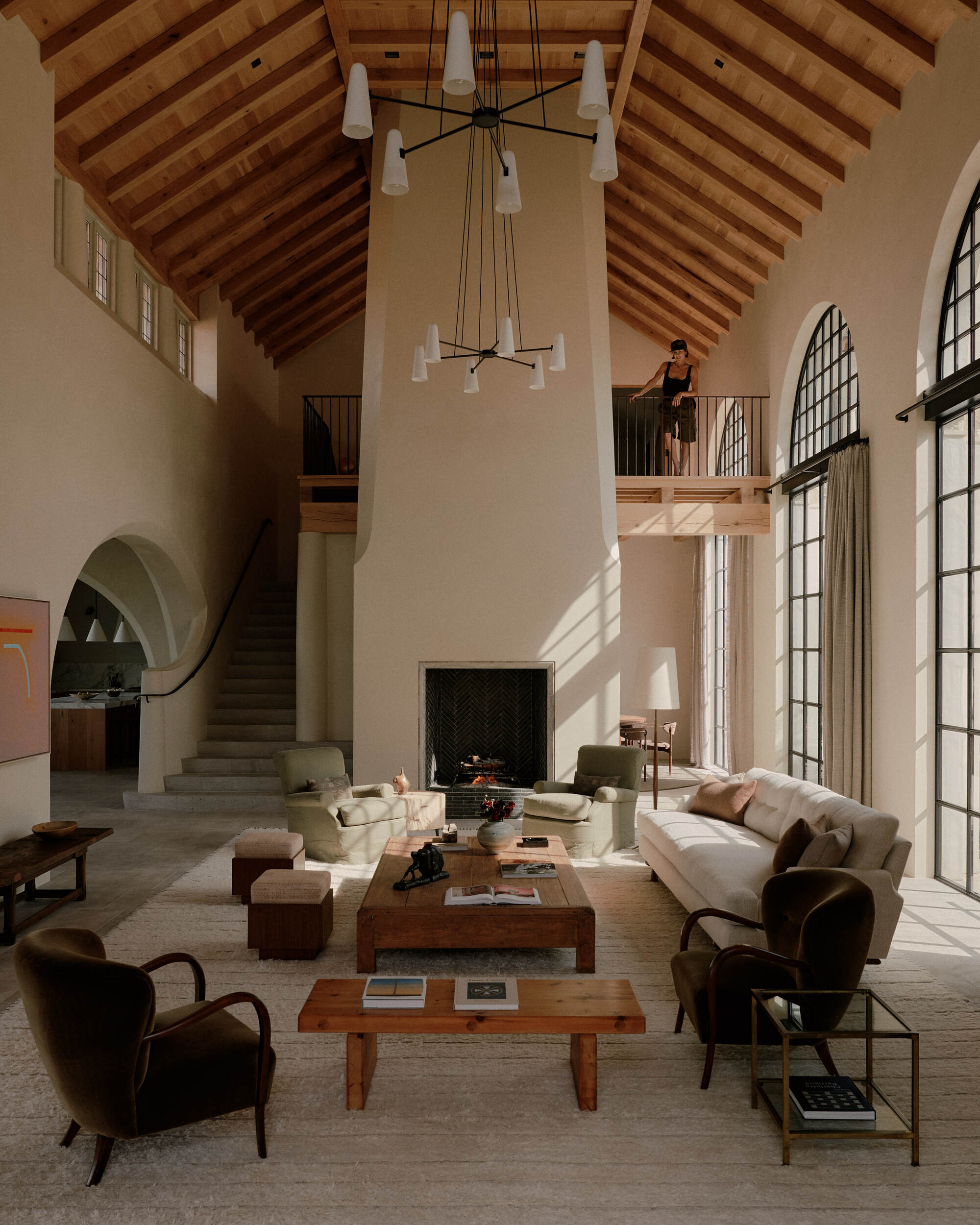 a mediterranean inspired living room with pitched ceilings